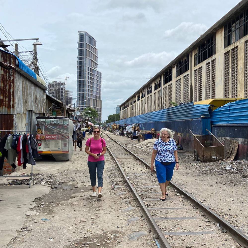 Kelly and Brenda walking though a slum together in Cambodia
